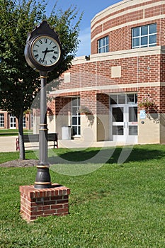 Clock by a modern brick building