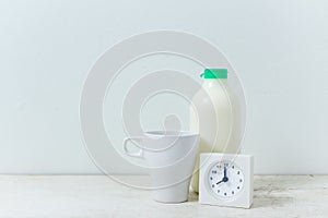 Clock in the morning time,milk on wooden background