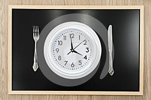 Clock next to a knife and fork