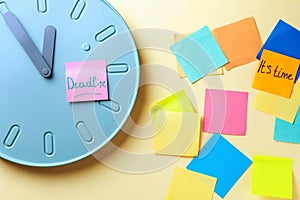 Clock with paper stickers on color table. Deadline concept