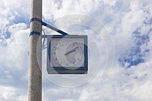 Clock on a pillar against a cloudy sky