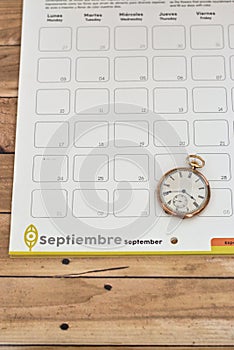 Clock on a planner on a wooden table - time management concept