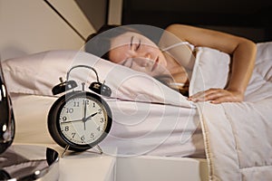 Clock show 2 O`clock and woman sleeping on bed