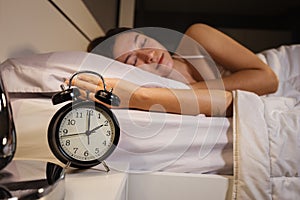 Clock show 2 O`clock and woman sleeping on bed