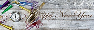 Clock strikes midnight for happy New Year theme with golden champagne and party decorations plus text