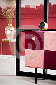 Clock on stylish commode in elegant living room interior