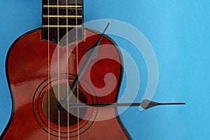 Clock tongues and ukulele on blue background