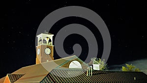 Clock toser over traditional roof building at night with black sky photo