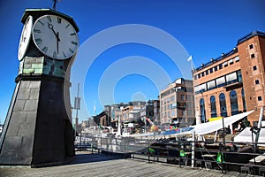 Clock tower on Aker Brygge Dock and modern building in Oslo, Nor