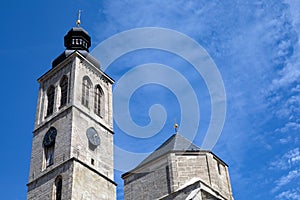 a clock tower of the catholic church against the blue sky on sunny day with copy space