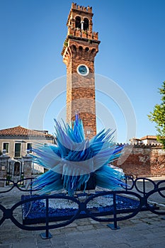 Clock tower of church of San Stefano and sculpture Comet of Glass, Murano, Italy