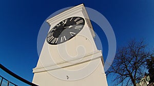 The clock tower on the fortress and the tree without leaves in autumn day in Serbia, city of Petrovaradin - Novi Sad.