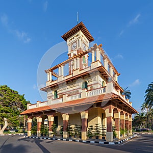 Clock tower in Montaza public park with decorated stone wall, green wooden window shutters, and red tile canopies, Alexandria