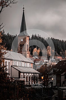 a clock tower near a bunch of houses on a hill