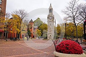 The clock tower near Gaffer District with the background of fall foliage in Corning, New York, U.S