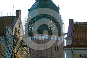 A clock tower seen between buildings