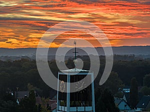 Clock tower at sunset with a cloudy orange sky in the background, Osnabruck, Germany