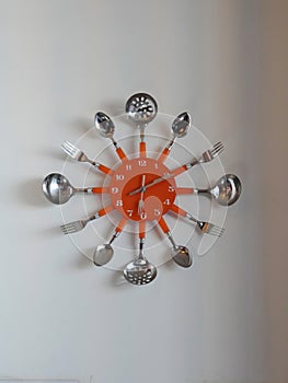 Clock on the wall decorated with kitchen utensils