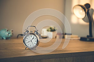 Clock on the  working wooden  table.