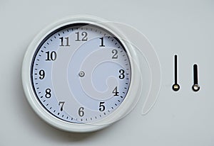 A clockface and an hour hand and the long hand of the wall clock