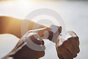 Clocking in a new time. Closeup shot of an unrecognizable man checking his smartwatch while exercising outdoors.