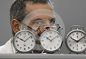 Clockmaker portrait behind his alarm clocks