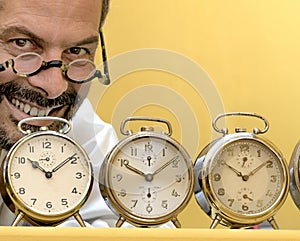 Clockmaker portrait behind his alarm clocks