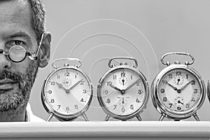 Clockmaker portrait between his alarm clocks