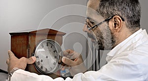 Clockmaker repairs clocks and watches  in his laboratory