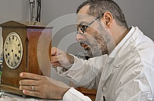 Clockmaker repairs clocks and watches  in his laboratory