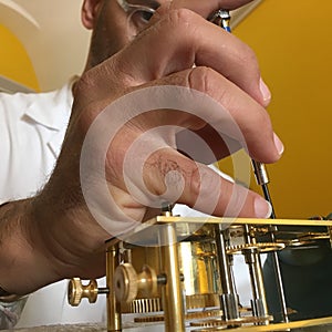 Clockmaker repairs clocks and watches  in his laboratory