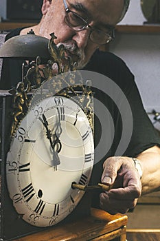 Clockmaker winding up a clockwork machine