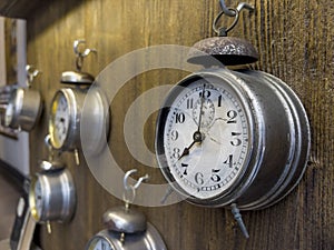 vintage alarm clocks hanged on wooden background