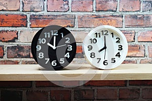 Clocks with time zone of different country on wooden shelves and brick wall background