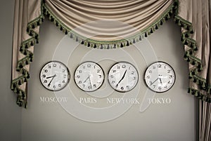 Clocks on a wall with time zone of different country