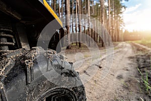 Clode-up detail of ATV awd quadbike motorcycle pov tyre view dirt country forest road beautiful nature morning sunrise