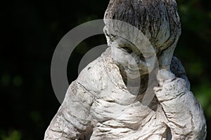 Cloes up photo of arden stone sculpture of a childern. Children statue.