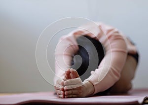 Cloese up hand.Asian woman working out in sportswear while doing yoga, seated in Child exercise, Balasana stance