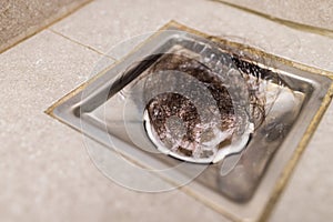 Clogged with dirty and hair over sewer pipe floor drain at bathroom