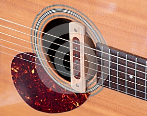 cloise up shot of acoustic guitar sound hole pickup type . made by wood, selective focus