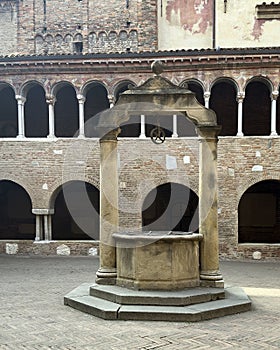 Cloister and ancient well in the Basilica of Saint Stephen in Bologna, Italy.