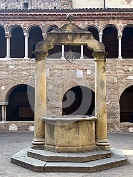 Cloister and ancient well in the Basilica of Saint Stephen in Bologna, Italy.