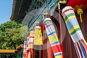 Clolorful Manchu banner and flags standing in front of ancient Chinese buildings, New Yuanming Palace, Zhuhai, China