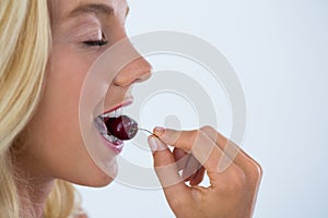 Clos-up of beautiful woman eating cherry