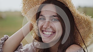 Close beautiful portrait of happy girl in hat smiling seductively into camera