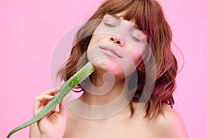 a close beauty portrait of a beautiful, sophisticated woman, on a pink background, with a beautiful styling, holding an