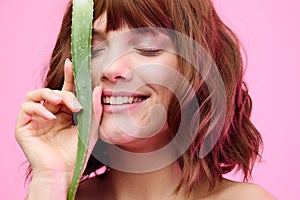 a close beauty portrait of a beautiful, sophisticated woman, on a pink background, with a beautiful styling, holding an