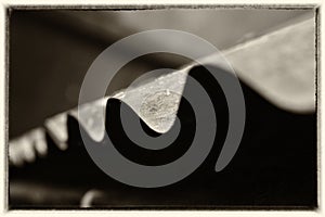 The close and black and white photography of the edges of rooftop made by tin with a frame