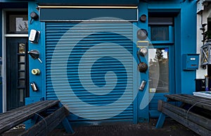 Close blue shop faÃÂ§ade with door and benches photo