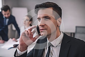 Close business mans face while talking on smartphone